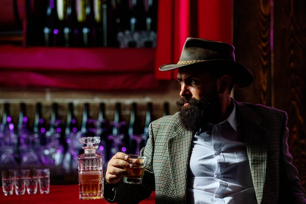 Homem elegante e elegante no desgaste clássico segurando vidro com wiskey na mão. — Fotografia de Stock