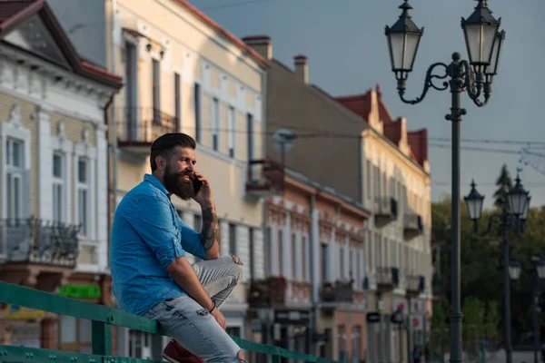 Bonito telefone de chamada homem e sorrir rua da cidade ao ar livre. Empresário em camisa azul casual falando no celular. — Fotografia de Stock