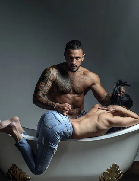 Sale réputation. Concept de trahison. Lave son corps sale. Un mec brutal qui nettoie une femme dans une baignoire. macho grossier laver fille sale avec éponge. ressentiment de barbu homme après trahison avec sexy femme — Photo