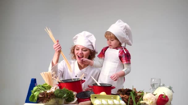 Anne ve kızı mutfakta birlikte yemek pişiriyor, mutlu bir aile. Çocuk Şefi. — Stok video