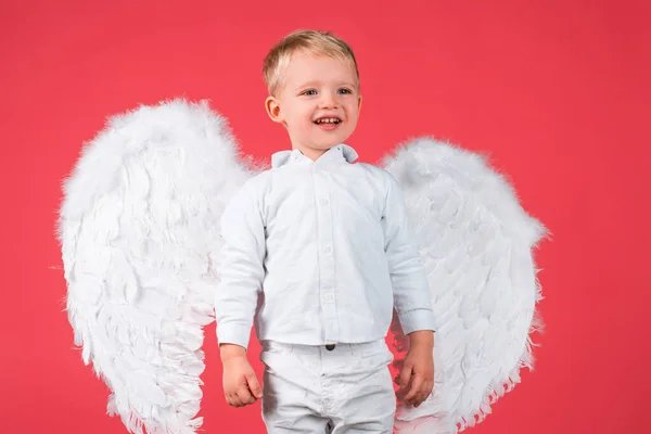 Menino pequeno anjo bonito com sorriso, isolado no vermelho. — Fotografia de Stock