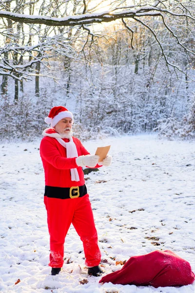 Rolig Santa läsa önskelista på julafton utanför. — Stockfoto