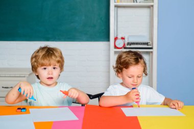 Çocuk arkaplanda bir tahtayla cevap vermeye hazır. Çocuk okulu. İlkokuldan elinde kitap ve çantayla bir çocuk. Kitaplı mutlu, zeki çocuk..