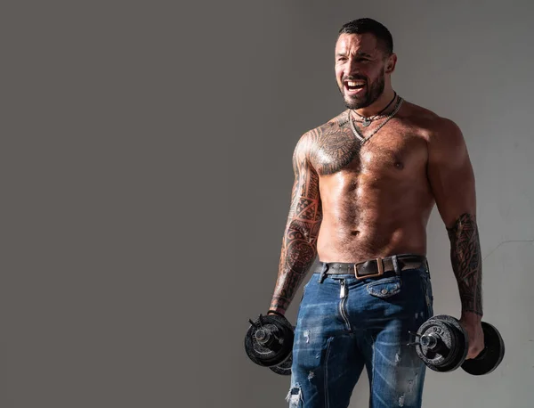 Man met duimbel. Musculaire Bodybuilder Guy doet oefeningen. Gespierde sexy man met naakte romp poseert met halter. Fitness concept. Mannetjesstuk. — Stockfoto