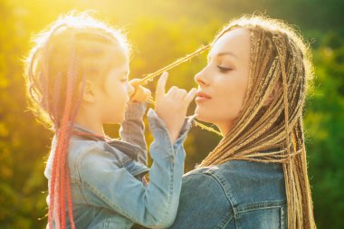 Saçlarını ören anne ve kızı. Örgü ören güzel bir kız çocuğu. Saç örgüsü modaya uygun..