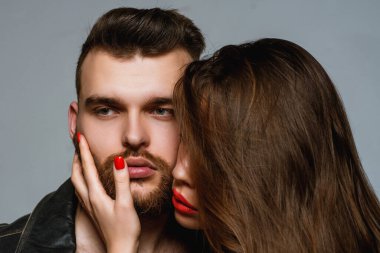 Man brutal well groomed macho and attractive girl cuddling. Girlfriend passionate red lips and man leather jacket. She adores male brutal beard. Passionate hug. Couple passionate people in love clipart