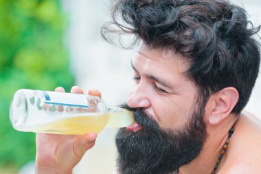 Sakallı adam alkol içer. Uzun sakallı adam bira tutar. Sakallı acımasız bir adam. Hispter tarzı. Alkolizm konsepti. Acımasız hipster 'ın kötü bir bağımlılığı var..