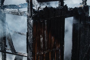 Yangın felaketinden sonra. Büyük yangından sonra duman. Yanıp kül olmuş ahşap ev.