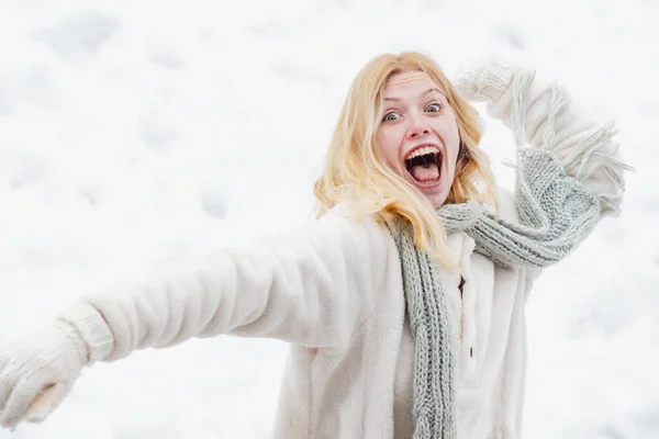 Porträtt av en lycklig kvinna på vintern. Glada flicka utomhus. Snöboll och vinternöje. Söt lekfull ung kvinna utomhus njuter första snön. — Stockfoto