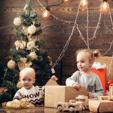 Şirin küçük kız içeride Noel ağacını süslüyor. Kış akşamı evde. Yeni yıl çocukları. Mutlu Noeller ve mutlu tatiller. Noel ağacı süslemesi.