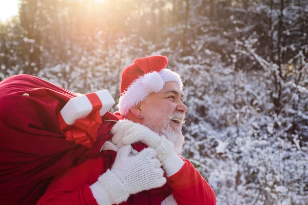 サンタクロースはクリスマスに冬の山の雪の中を歩く. — ストック写真