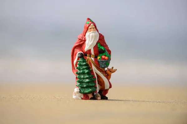 Санта Клаус, концепция тропических каникул. Рождественские или новогодние украшения на фоне морского пляжа с копировальным пространством. — стоковое фото