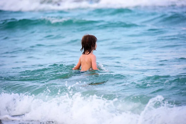 Petit garçon jouant en plein air sautant dans l'eau pendant les vacances d'été sur l'île de plage tropicale. — Photo