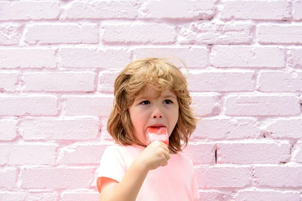 Παιδί τρώει icecream σε ένα ροζ φόντο τοίχο. — Φωτογραφία Αρχείου
