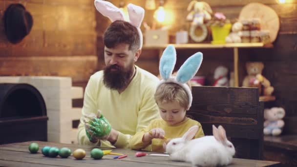 Baba ve oğul Paskalya için yumurta boyuyor. Paskalya tavşanı ile aile oyunu. — Stok video