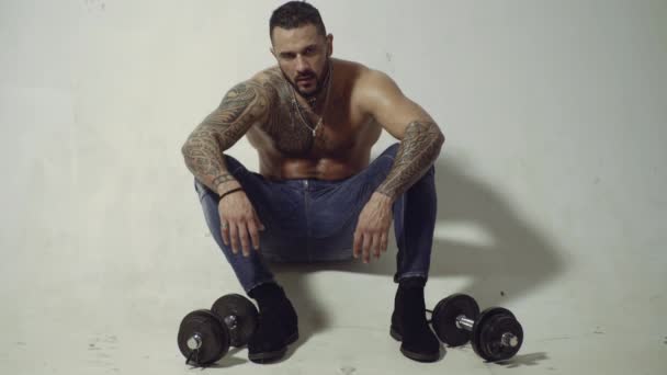 Мускулистый мужчина после тренировки в тренажерном зале с гантелями, сильная сексуальная модель. — стоковое видео