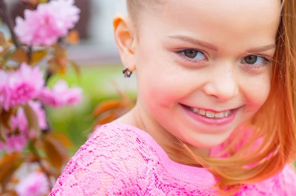 Carino felice ragazza gioiosa con i capelli lunghi da vicino. Primavera. L'infanzia. Buffo, Holliday. Bambino carino divertirsi in una giornata di sole all'aperto. Buon giorno.. — Foto Stock