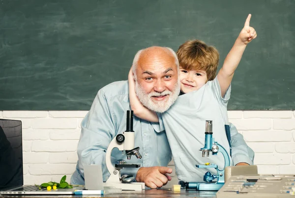 Alumno inteligente y viejo profesor de aprendizaje en fondo pizarra pared verde. De vuelta a la escuela y a la educación en casa. Gracias Maestro. Alumno estudiando en el aula. — Foto de Stock