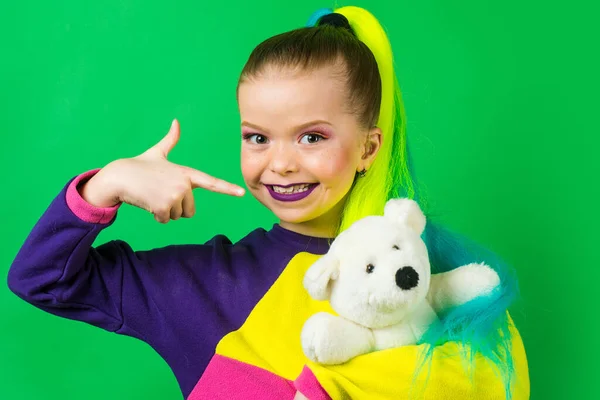 Klein model met gekleurd haar omhelzend en wijzend op Teddy Bear. Het concept van kinderbijsluiters.Textielgevoelig speelgoed. — Stockfoto