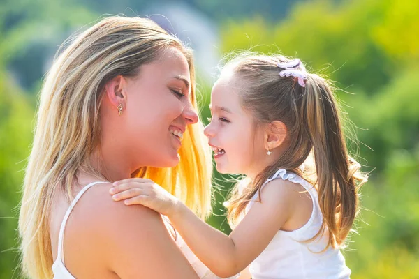 Amor infantil. La familia feliz y la mamá encantadora y la hija pasan el tiempo juntos - el día de las madres. Día de las madres. Madre e hija disfrutan y miran a la cámara. —  Fotos de Stock