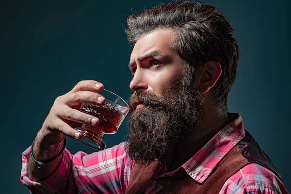 Man Bartender med skägg håller glas konjak. Sommelier smakar dyr alkoholdryck. — Stockfoto