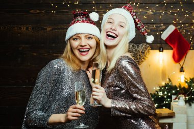 Noel hazırlığı. Lüks iki kız yeni yılı kutluyor. Noel kız arkadaşları kız arkadaşlar için giyinir. Noel elbisesi giymiş iki güzel kız.