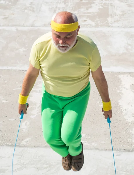 Old man skipping rope. Fitness senior man skipping with a jump rope outdoors. — Stock Photo, Image