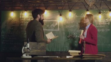 Profesör ve sekreter tahtada çalışıyor. Öğrencilere matematik öğreten profesörün portresi. Tahtaya yazı yazarken matematik problemini çözen genç bir kadın. Öğretmen konsepti.