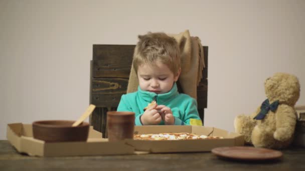 Rapaz giro a comer pizza em casa. Crianças comida favorita. Conceito de comida para crianças, criança faminta feliz comer pizza. — Vídeo de Stock