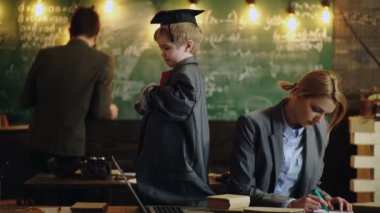 Anaokulundaki çocuklar. Ebeveynler, çocuklarına ev ödevlerinde yardım ediyorlar. Baba, anne ve oğul öğreniyor. Çocuk eğitimi. Küçük zeki dahi..