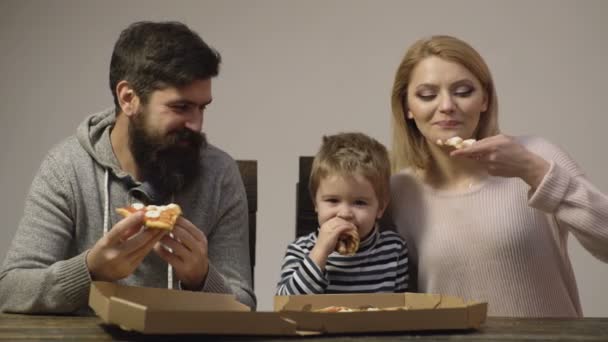 Père mère et fils mangeant de la pizza à la maison. Garçon avec de la nourriture préférée. concept de nourriture familiale heureuse, homme heureux affamé manger pizza. — Video