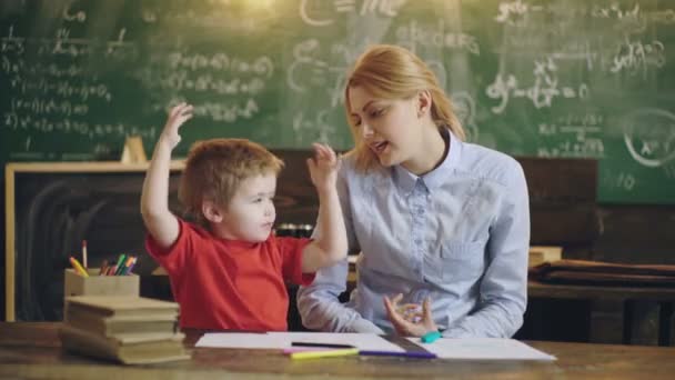 Základní škola. Mládě ve školce. Roztomilý malý chlapec studující na třídě s učitelem. — Stock video