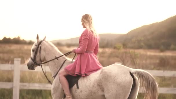 Een jonge vrouw die paardrijdt. Meisje loopt op een ranch met paarden. — Stockvideo