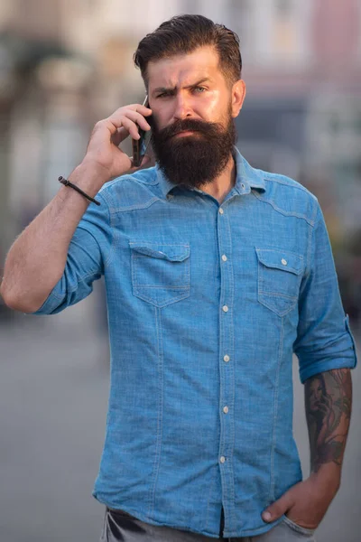 Człowiek spacerujący po ulicy rozmawiając przez telefon komórkowy. — Zdjęcie stockowe