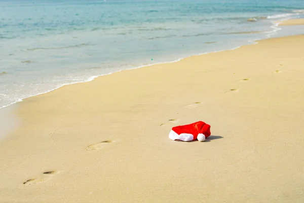 Weihnachtsmütze am Meer. Weihnachts- und Neujahrsurlaube in heißen Ländern. — Stockfoto