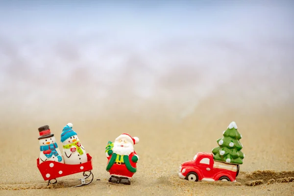 Mikołaj i bałwan dekoracji na plaży oceanu. Święta Bożego Narodzenia i Nowy Rok wakacje w gorących krajach. — Zdjęcie stockowe