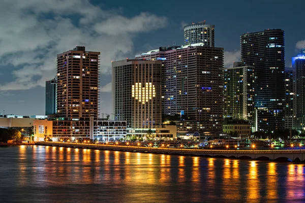 Miami natt nere i stan, Florida. Miami Florida vid solnedgången, skyline av upplysta byggnader och Macarthur Causeway bron. — Stockfoto