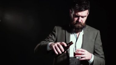 Elinde bir bardak Wiskey tutan yakışıklı bir adam. Neşeli sakallı adam pahalı viski ya da konyak içiyor..