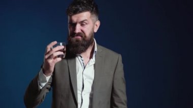 Klasik takım elbiseli şık bir adam elinde viski, konyak ya da konyakla bardak tutuyor. Klasik lüks, pahalı, zengin viski. Klasik retro barmen güveni..