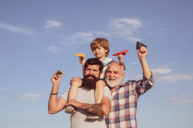 Üç erkek nesli. Babasıyla dışarıda oynayan sevimli bir oğlu var. Babalar Günü - Büyükbaba, baba ve oğul kucaklaşıyor ve birlikte eğleniyorlar..