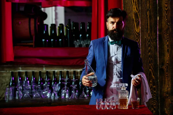 Barman kelner w barze. Barman z brodą trzyma szkło z alkoholem. — Zdjęcie stockowe