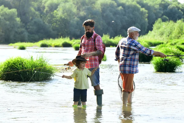 Tre generazioni di età: nonno, padre e giovane figlio adolescente. Nonno e padre con ragazzo bambino carino stanno pescando. La pesca è diventata un'attività ricreativa popolare. — Foto Stock