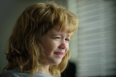 Ağlayan çocuk. Evde gözyaşı döken üzgün çocuk..