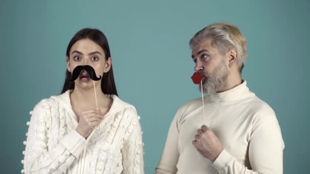 Funny couple change gender. Funny and Crazy Idea. Humorous video. Human emotions, youth, love and lifestyle. Stereotypical gender roles. Couple with paper mustache and female red lips. Royalty Free Stock Footage