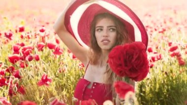 Moda manyağı bir kadının açık hava portresi. Şapkalı kız, kır çiçekli gelincik ile sahada rahatlıyor. Spring Meadow 'da trend modeli. Genç ve romantik Bahar Stili