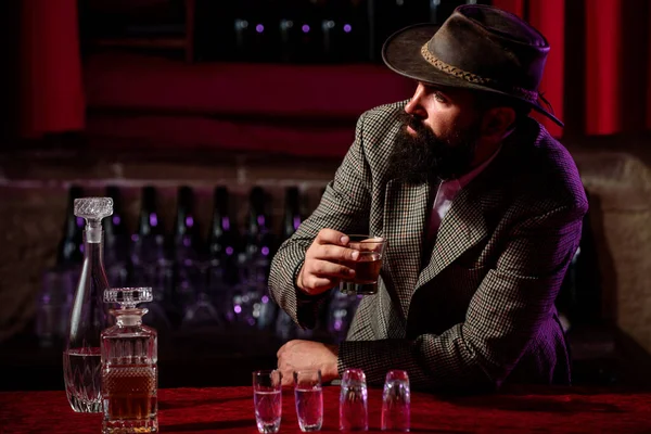 Pijany mężczyzna trzymający whisky po tym, jak wypił dużo alkoholu i poczuł ból głowy. Koncepcja alkoholu. — Zdjęcie stockowe