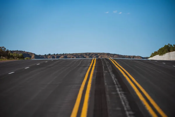 Carretera de asfalto vacía y cielo azul. Panorama del camino en el soleado día de verano. —  Fotos de Stock