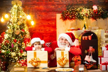 Noel çocuğu. Küçük Noel Baba 'nın Noel odasında olmasına şaşırdım. Noel Baba yardımcısı ve hediyeli büyükbaba. Noel mucizesine inan..