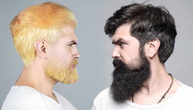 Erkekler portre yapar. Ciddi bir adamın profili yakın plan sakallı ve bıyıklı, ciddi ve izole görünüyor. Hippi seksi adam, erkek ifadesi. Renkli saç. Erkek sakalı ve bıyığı. Esmer sarışına karşı..