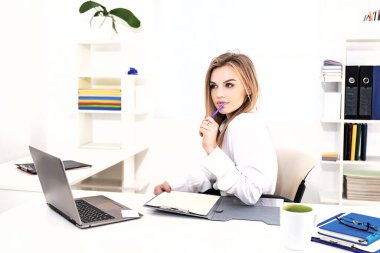 Ofisteki güzellik işindeki kadın. Güzel sarışın sekreter kadın ofiste çalışırken panoya notlar yazıyor..